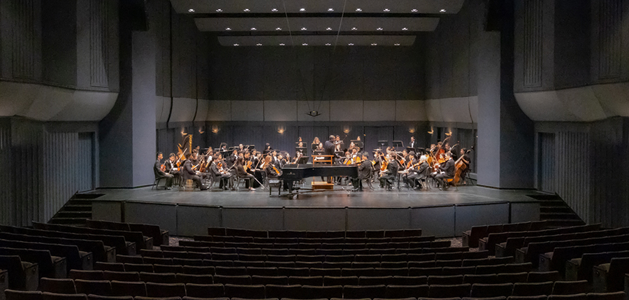 A wide shot of the full symphony orchestra onstage at Irvine Barclay Theatre