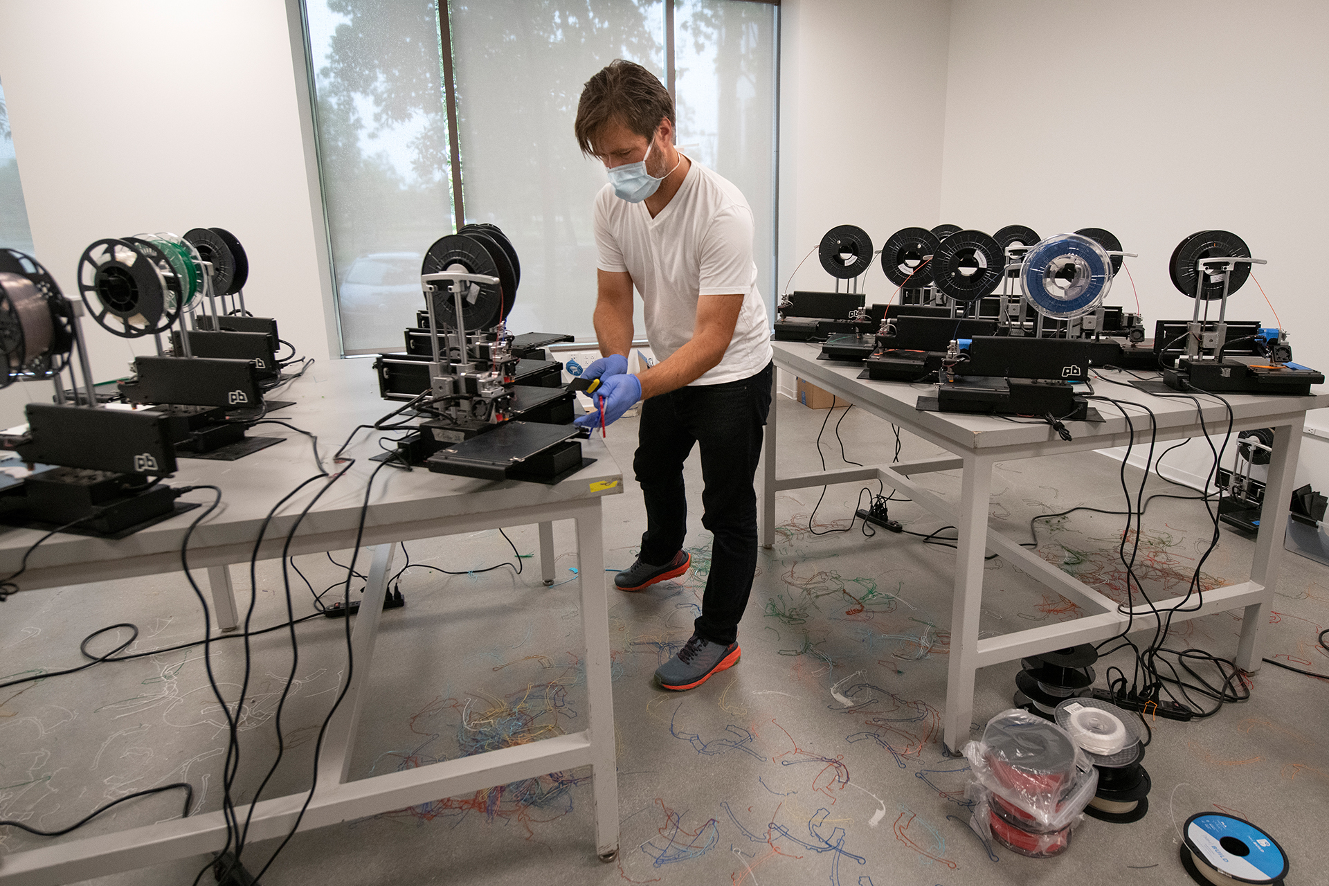 Jesse Colin Jackson setting up a 3D printer to print PPE face shield components.