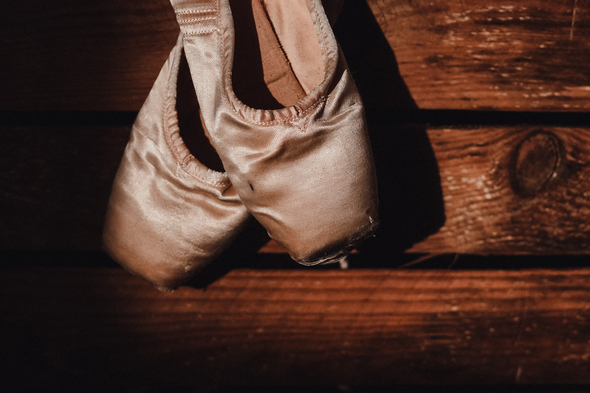 Ballet slippers on wood stairs.