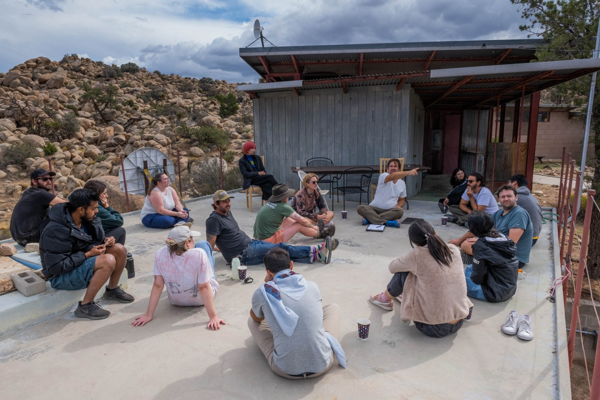  Jesse Colin Jackson (center pointing) lectures to a cohort of students from the various disciplines at Burns Pi.on Ridge Reserve. (Photo: Hiroshi Clark)