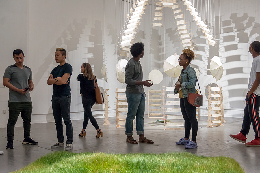 Students gather during the opening of an M.F.A. Thesis exhibition in the Contemporary Arts Center Gallery.