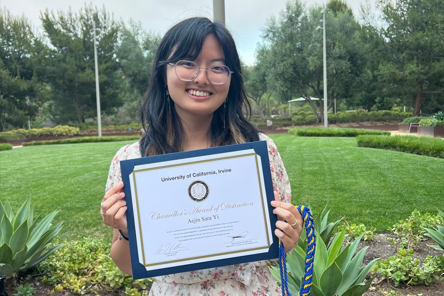 Aejin Yi holds a certificate for receiving the 2025 Chancellor's Award of Distinction.