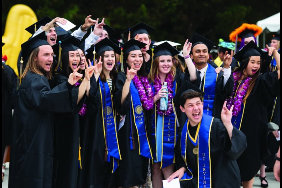 Excited UCI graduates from the Class of 2019 cheer in caps and gowns