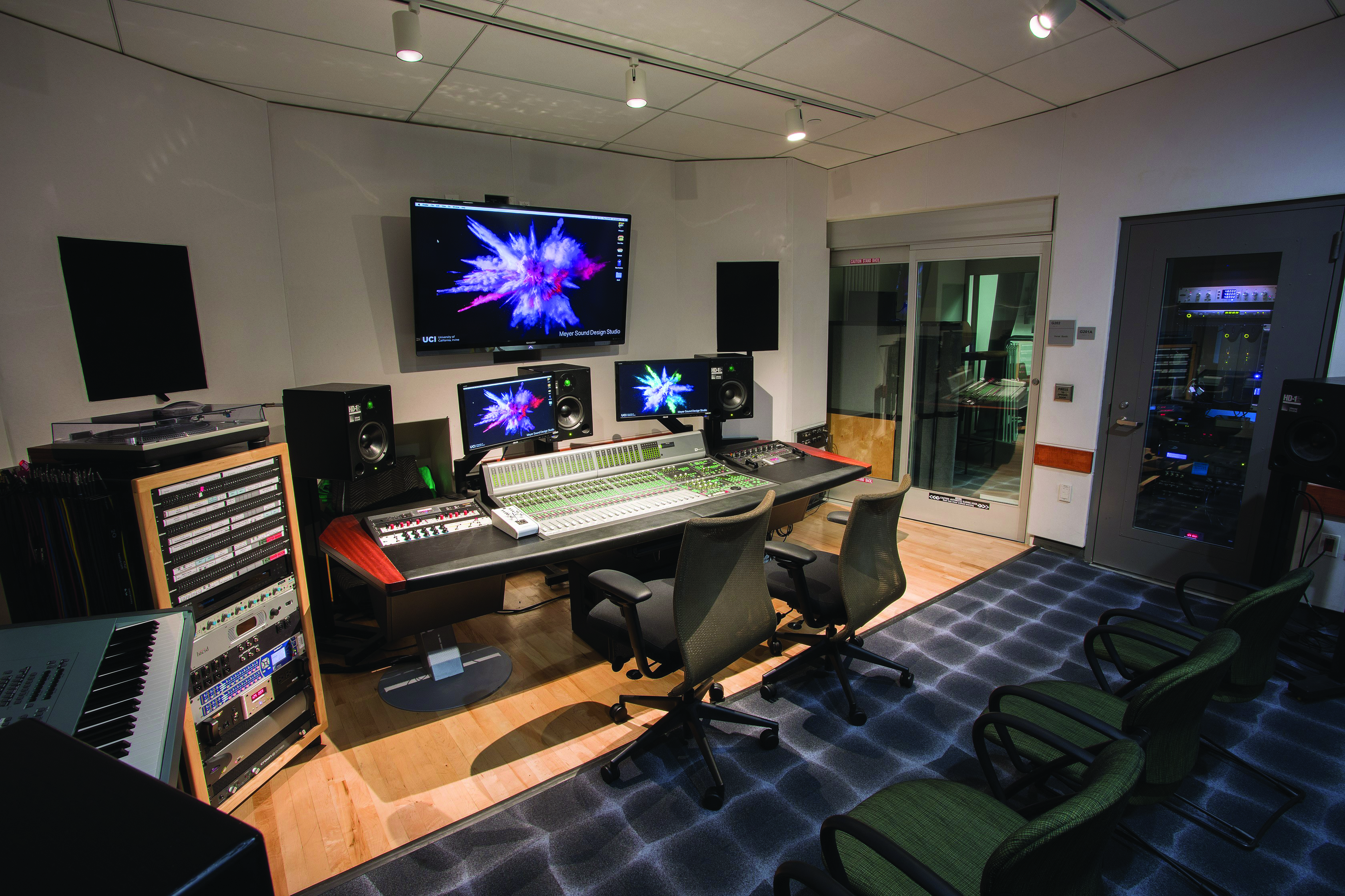 Meyer Sound Studio, A professional sound design studio with a large mixing console, multiple monitors and speakers, recording equipment racks, and seating facing the control desk.