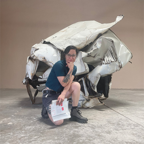 Beatrice Schleyer posing with a John Chamberlain sculpture at The Chinati Foundation in Marfa, Texas