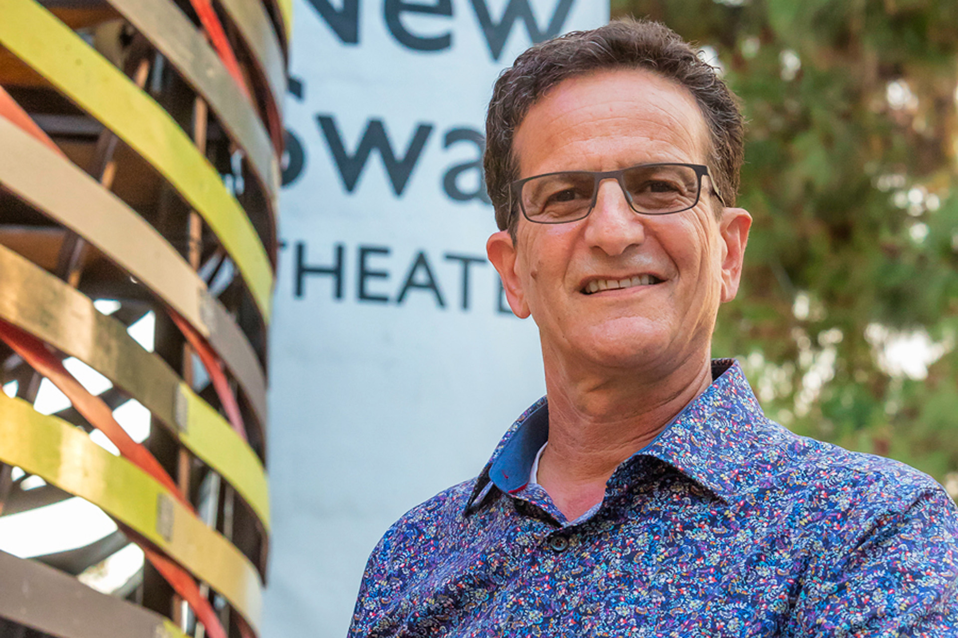 Eli Simon smiling in front of New Swan Theater