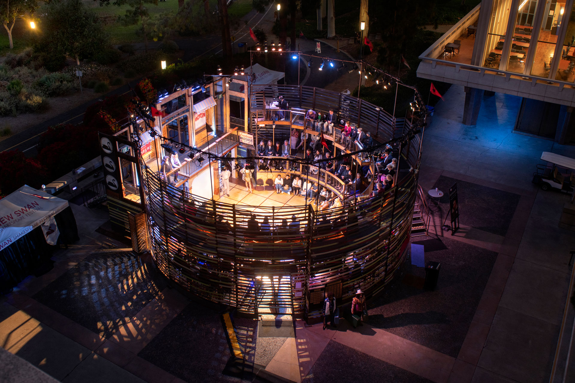 New Swan Shakespeare Festival outdoor theater at UC Irvine, with audience surrounding the stage during an evening performance.