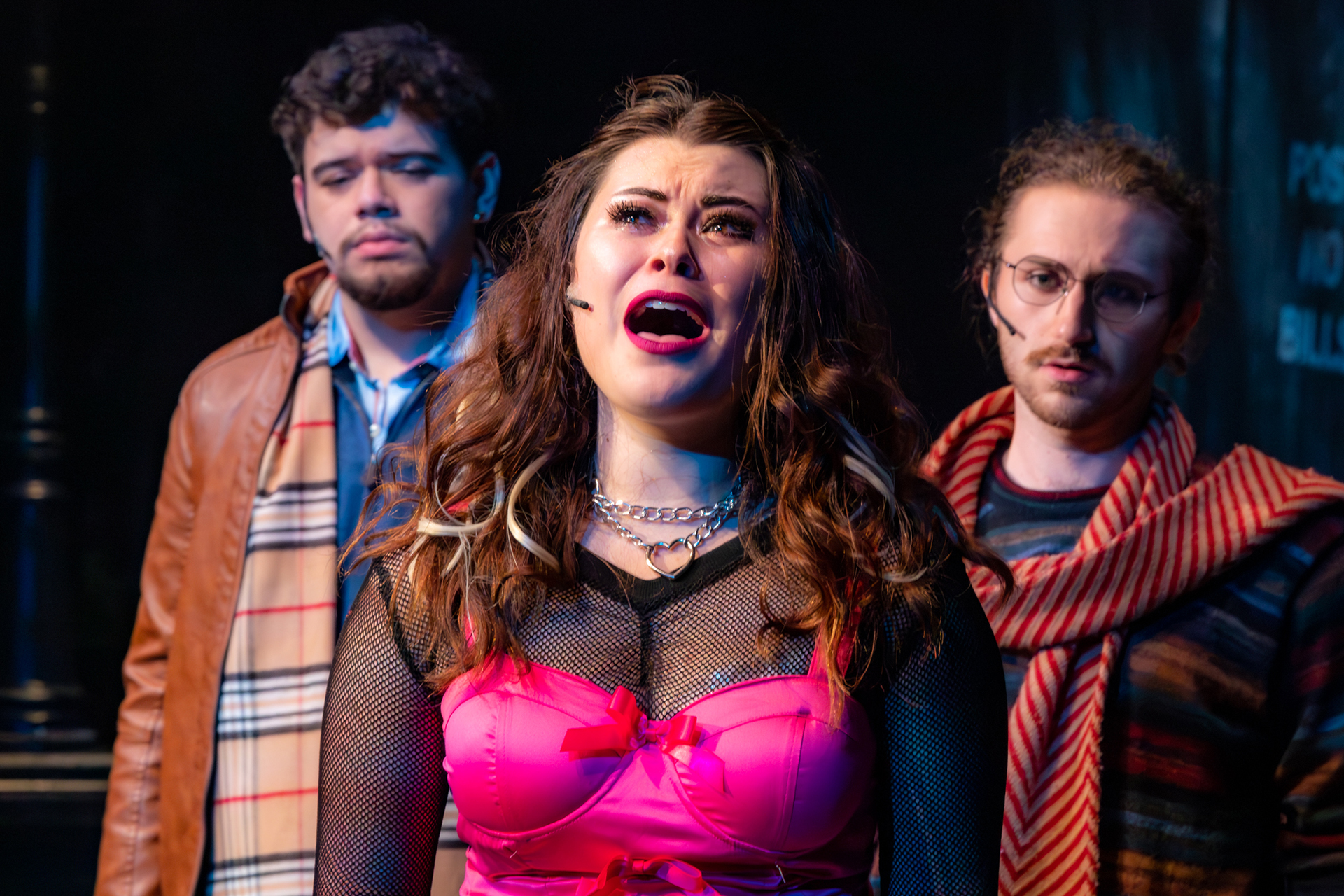 UCI Drama student performs an emotional musical theatre solo, supported by cast members on stage