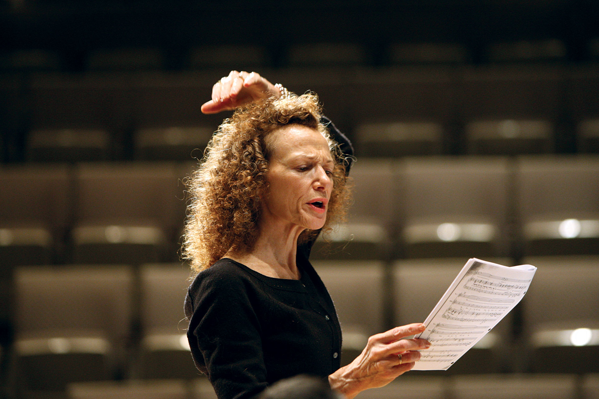 UCI Drama music theatre professor Myrona Delaney leads a vocal rehearsal, conducting while reading from a score