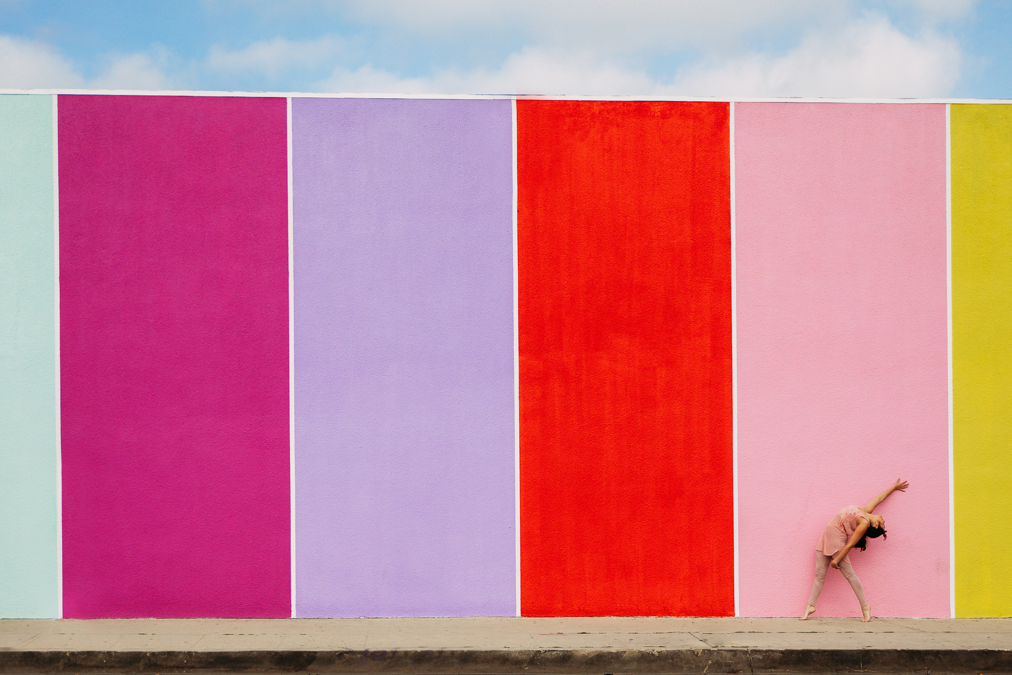 Maia Correia-Fill in front of a color-blocked, warm palette wall.