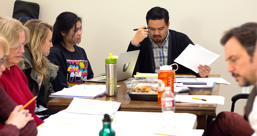 Actors and artistic staff sitting around table, in a meeting setting