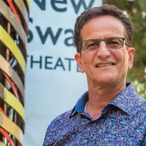 Eli Simon smiling in front of New Swan Theater