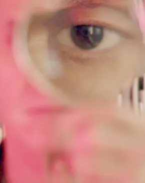 Patricia Olynk, The Mutable Archive, film still. Courtesy of the Artist. (Close-up of a person’s eye viewed through a magnifying glass)