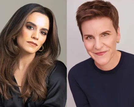 Side-by-side portraits. On the left, Sepideh Moafi, with long brown hair and gold hoop earrings, wears a black satin blouse against a gray background. On the right, Jenn Colella, with short auburn hair, smiles in a navy sweater against a light background.