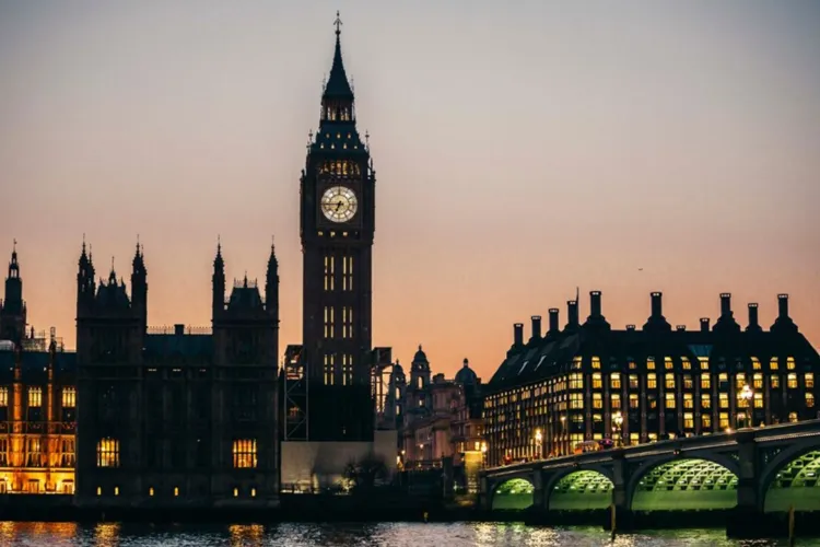 A sunset view of London’s skyline, featuring Big Ben and the Houses of Parliament illuminated along the River Thames.