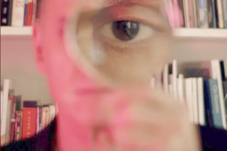Patricia Olynk, The Mutable Archive, film still. Courtesy of the Artist. (Close-up of a person’s eye viewed through a magnifying glass)