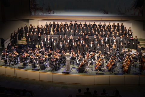 Choir on stage on risers with conductor in front