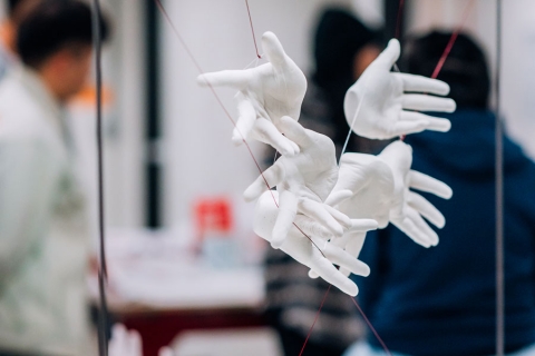 Art installation consisting of gloved hands suspended in air