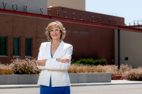 Dean Tiffany Lopez stands in a blue dress with a white blazer in front of the main CTSA sign