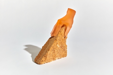 Artwork of a hand on a triangular brick