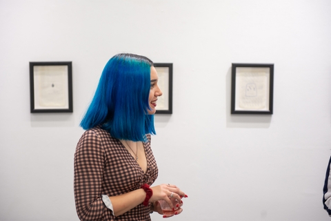 Woman with blue hair in an art gallery