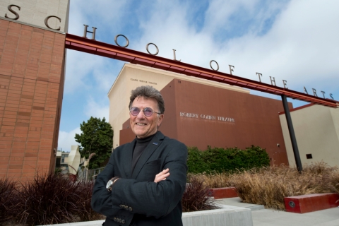 Dean Stephen Barker stands in front of the main Claire Trevor School of the Arts sign