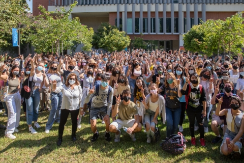 Hundreds of students stand in the meditation garden in front of the Contemporary Arts Center.