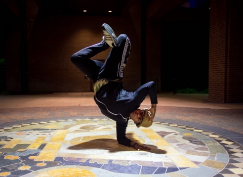A photo of Cyrian Reed up on one arm performing a "breakdance" move