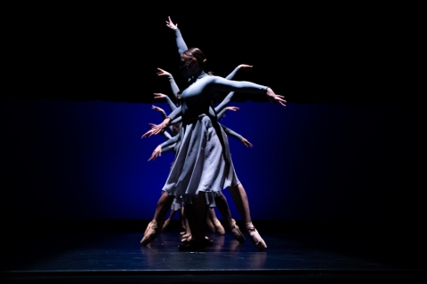 Dancers in a line, behind each other, with arms outstretched