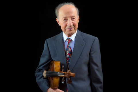 Jerzy Kosmala, in suit and tie, holding his viola under his arm