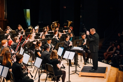 Wind ensemble musicians on stage during a concert