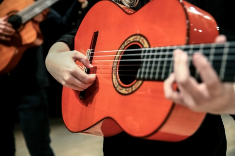 Closeup of a red-orange wooden guitar