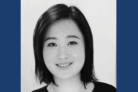 Black and white headshot of smiling woman with short black hair