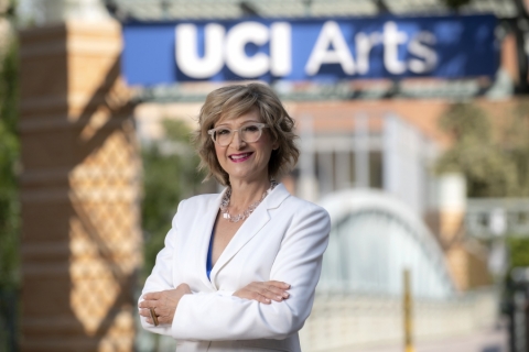 CTSA Dean, Tiffany López, standing in front of a sign reading UCI Arts