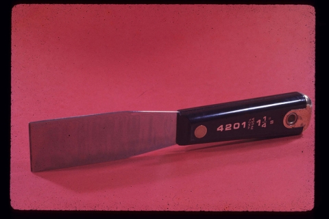 image of 1.25" putty knife with black handle imprinted with numbers 4201; against a red background