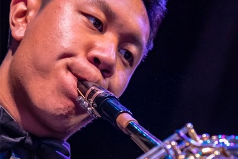 Closeup of musician with lips to reeded instrument