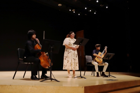 Guitarists on stage during a concert, with an accompanying vocalist