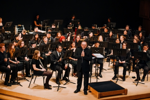 Wind ensemble musicians on stage during a concert