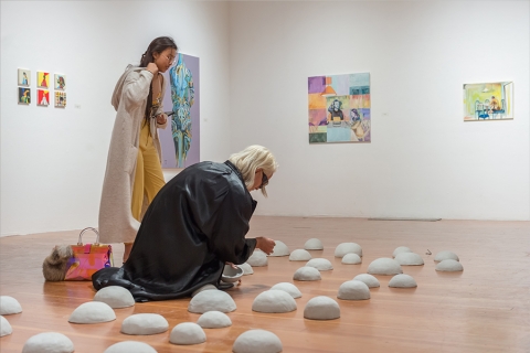 Exhibition space with someone kneeling on floor