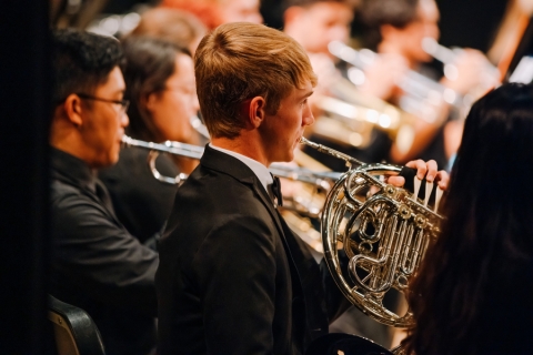 Wind ensemble musicians on stage during a concert