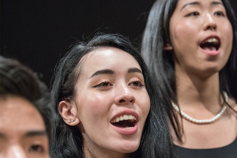 Women with long, dark hair singing in a choir