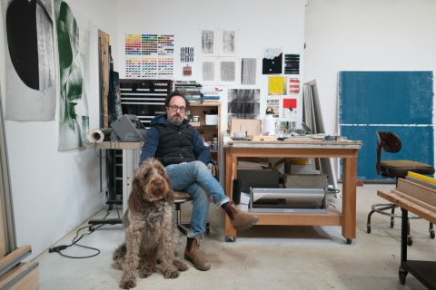 A person sitting on a desk with a dog