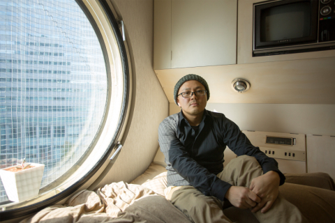Person in beanie and glasses by circle window
