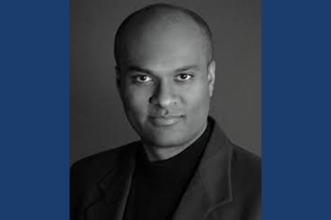 Black and white headshot of bald man in suit jacket