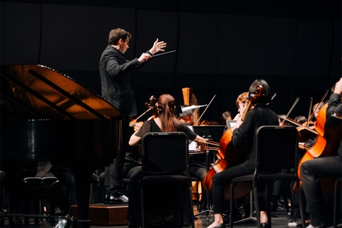 Symphony musicians on stage with their conductor