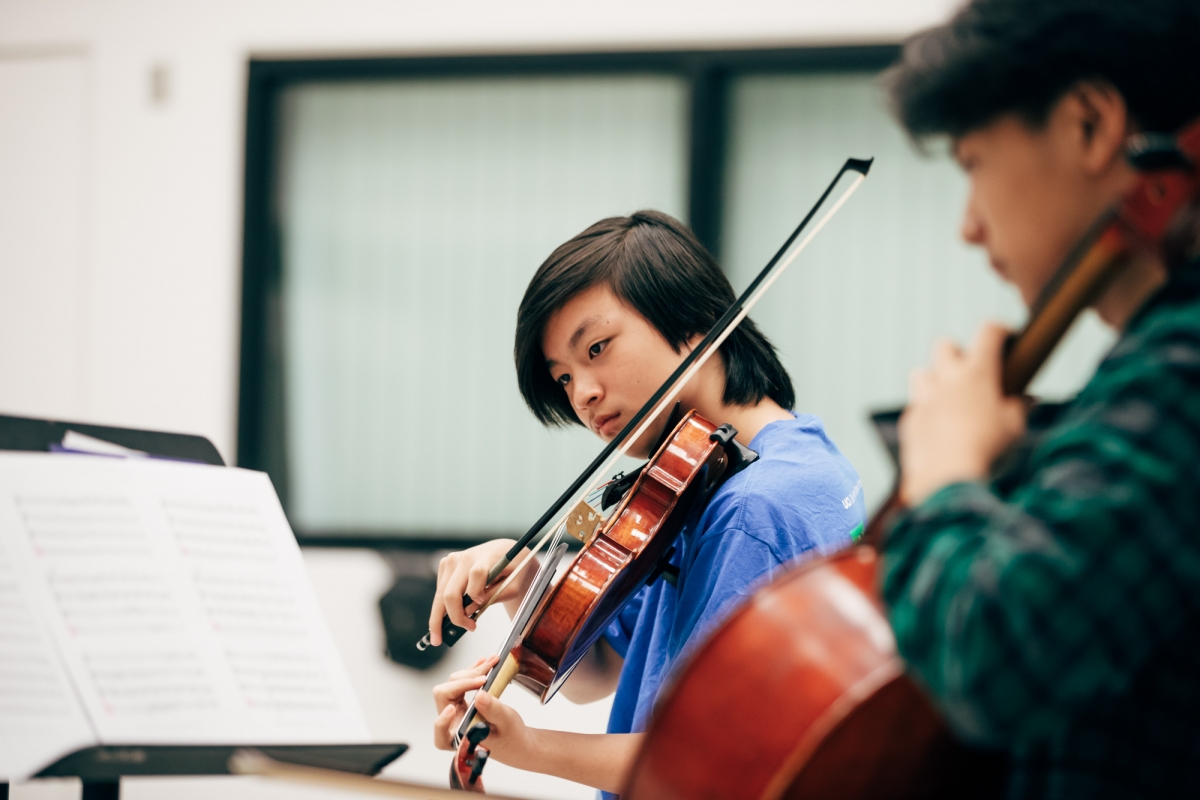 Student with violin to chin, bow mid-air